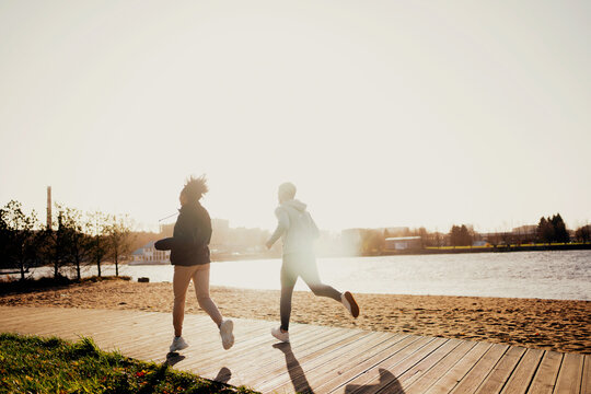 Cardio training sports young people. Stretching exercises running on the embankment in the city center. Comfortable sportswear. A couple in love shows a workout. Healthy lifestyle
