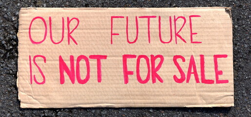 Handgeschriebener Slogan auf einer Pappe: "Our future is not for sale."