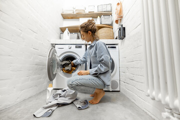 Woman washing clothes at home - obrazy, fototapety, plakaty