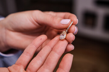 Earrings in the hands of the bride. Bridal wedding accessories