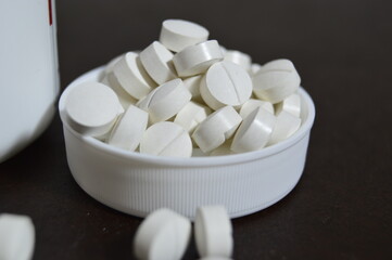 Fototapeta na wymiar white pills in the cap
