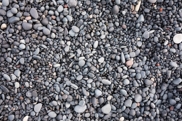 Gray pebbles as a background in the Iceland sea shore. Abstract composition. Design image.