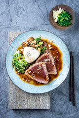 Modern style traditional Japanese tuna tataki with vegetable and onigri served as top view on a...