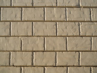 Background of a yellow wall of a city building. The texture of brickwork made of small bricks and large blocks. The concept of the facade of the house for computer modeling.