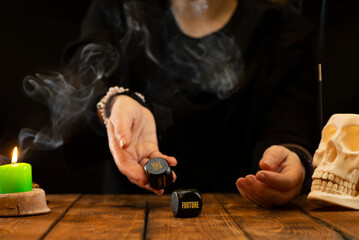 A fortune teller or oracle throws black dice, predicting the future, a good deal. Psychic readings...