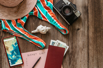 Travel concept banner flat lay.Items for summer vacation: passport,swimsuit,hat,money,smartphone with Asia map,retro camera copy space.Top view vacation concept.Planning fun trip.Travel accessories