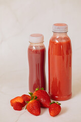 Red smoothie in a bottle next to 
 strawberries. Eat lots of fruits. Red healthy fruits	