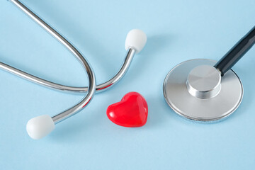 Heart and stethoscope on blue background. Heart health, health care, cardiology concept. 