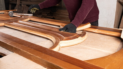 the master is engaged in the restoration of the wooden door in the workshop