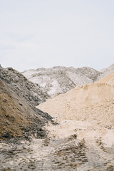 Heaps of sand at a construction site on an overcast day