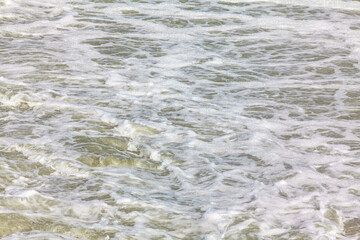 Surface of flowing water with foam . Dangerous place for swimming