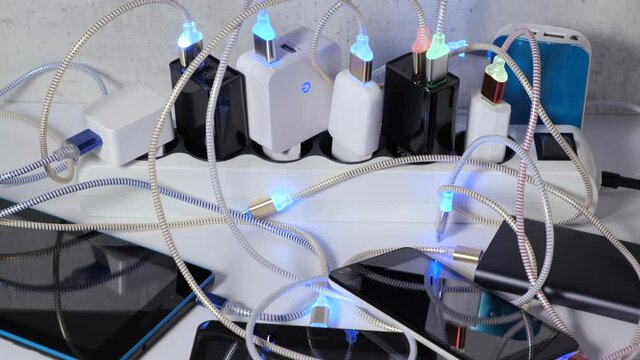Connect Smartphone Mobile Phone and tablets connected to Charging hub on the Table, micro usb   wires to chargers in sockets with LED light Blinking. Extension cord switch loaded