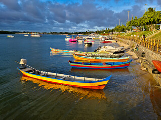 Barcos a remo coloridos ancorados na beira de um rio - obrazy, fototapety, plakaty