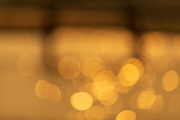 Abstract photo of bokeh on the surface water of sea or ocean at sunset time with golden light tone.
with blurry wooden bridge.