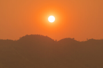 Sunrise over mountains and forest  with sky and sunbeams.