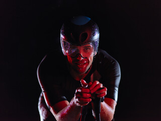 triathlon athlete riding bike at night