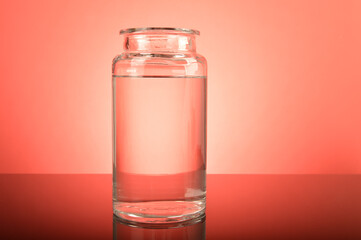 Glass jar with water on the table.