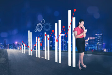 Businesswoman using mobile phone near growth chart