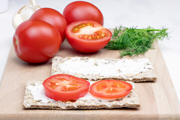 Healthy food. Diet. Crispbread with garlic sauce and tomato on a cutting board. Rye bread rolls. Vitamins. Parsley