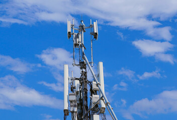 Telecommunication tower of 4G and 5G cellular. Macro Base Station. 5G radio network telecommunication equipment with radio modules and smart antennas mounted on a metal against blue sky background.