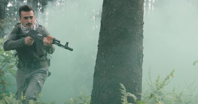Terrorists running thorugh dense forest with smoke or haze in backgorund, terrorist in dangerous action in smoky forest