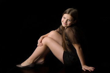 Smiling girl sitting on floor hugging her knees