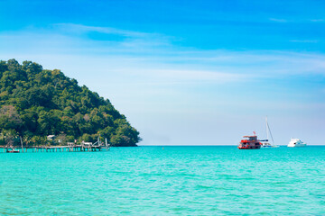 Koh Kood island is emerald green sea in the clear blue sky during the day time.