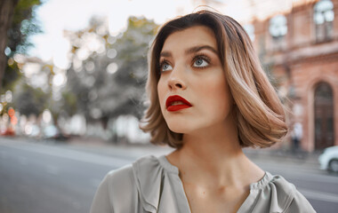 Obraz premium beautiful blonde walks down the street near historic buildings in nature