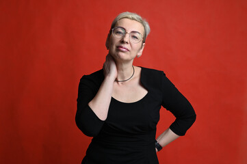 Portrait of adult blonde caucasian woman in glasses on red background