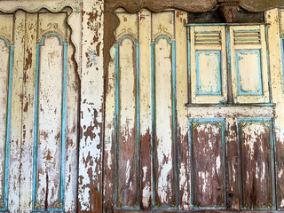 Old and weathered wooden door and window (broken white colour). Vintage background of old wooden door.