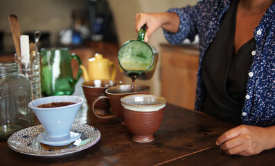 barista preparing brewing coffee with coffee maker and drip kettle.