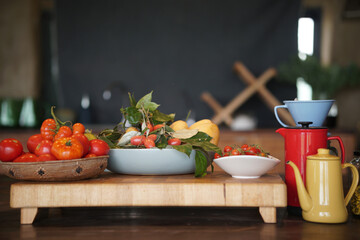 tomatoes, lemon, Indian ivy-rue and tea pot in kitchen
