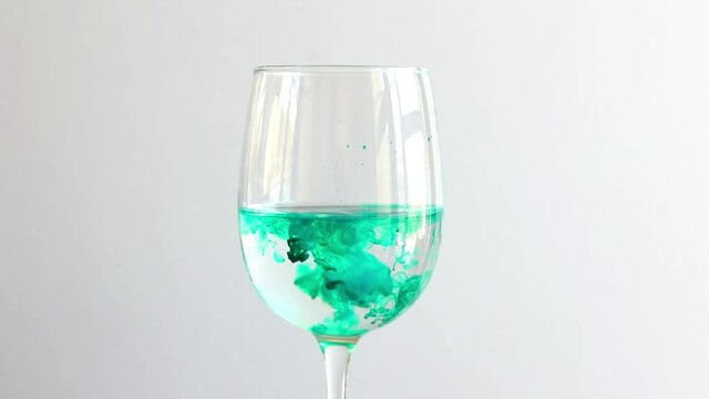 ink colors drops in water, wine glass. colorful underwater painting.