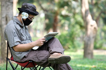 Man reading book in garden background and relaxing on holiday