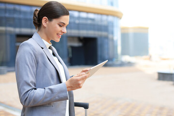 Fototapeta premium Business woman at work with tablet near office outdoors.