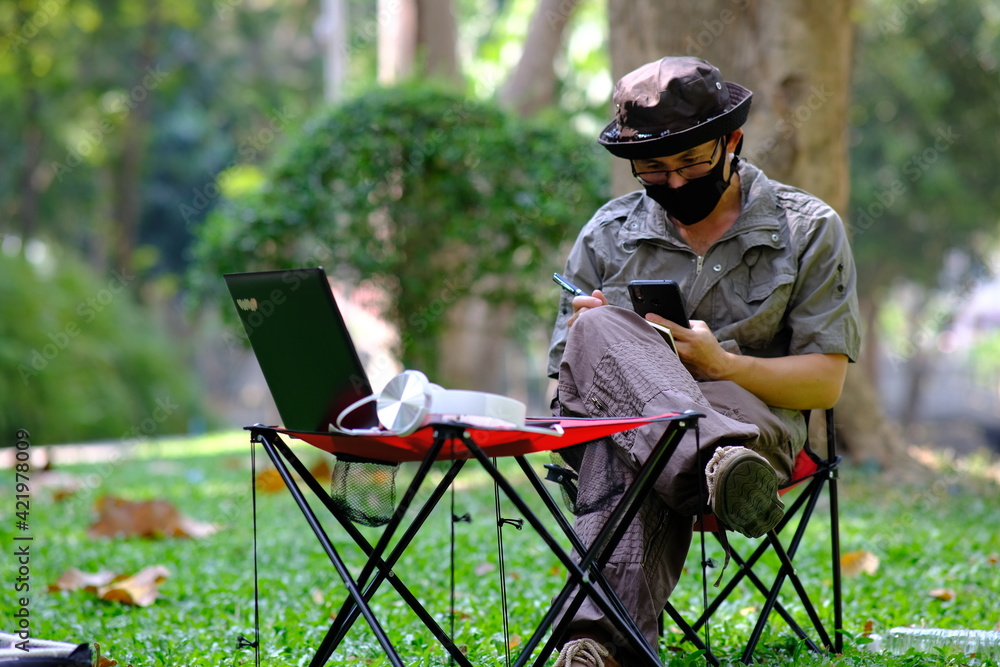 Poster man using smartphone in garden background and business concept