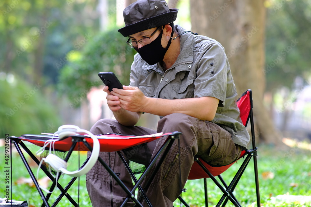 Aufkleber man using smartphone in garden background and business concept