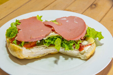 bologna sandwich with lettuce, bread, mayonnaise and ketchup