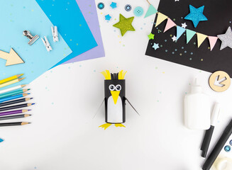 Step-by-step instructions for making a penguin with children from a toilet roll of paper and...