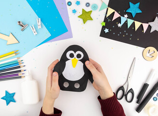 Step-by-step instruction of making a penguin out of paper with children. Step 5