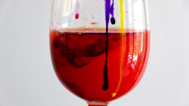 ink colors drops in water, wine glass. colorful underwater painting.