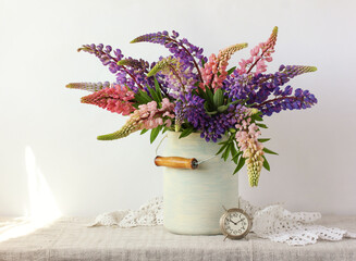 bouquet of lupines and a metal alarm clock