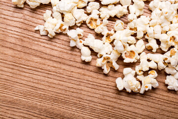 Obraz na płótnie Canvas Heap of delicious popcorn isolated on wooden background. popcorn close-up