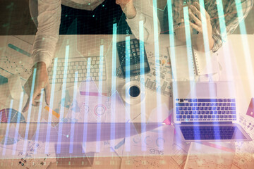Double exposure of man and woman working together and financial graph hologram drawing. market...