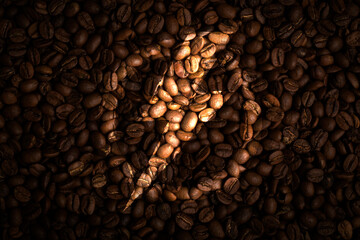 Silhouette of a sign of energy on a dark background of coffee beans. Concept of refueling fuel for cheerful and energy