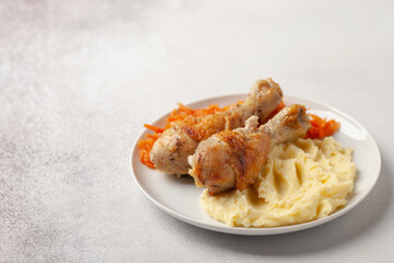 Chicken drumsticks grilled with cabbage salad coleslaw and mashed potatoes in a plate on the table. Healthy food