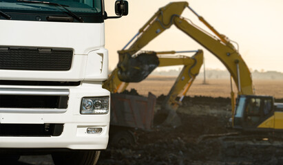 Close up of a truck on a background of excavator at work in the site