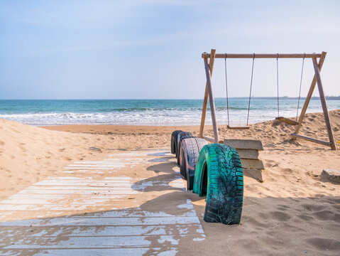Wooden board path over the sand and swings at Mangalia beach, in Romania.