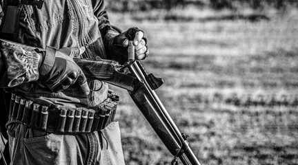 A hunter with a hunting gun and hunting form to hunt in an autumn forest. The man is on the hunt....