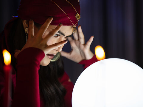 Asian witch using crystal ball to see future
